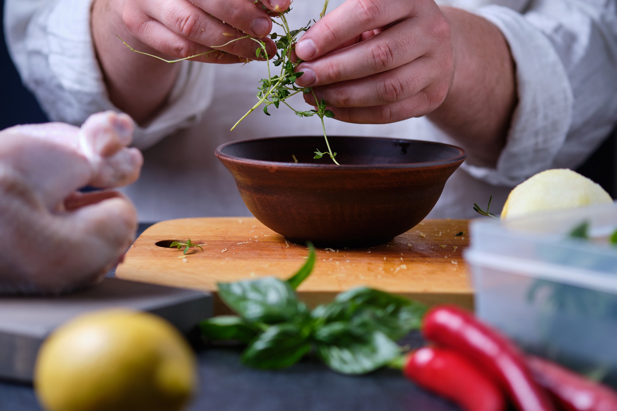 chef arranging herbs over a bowl