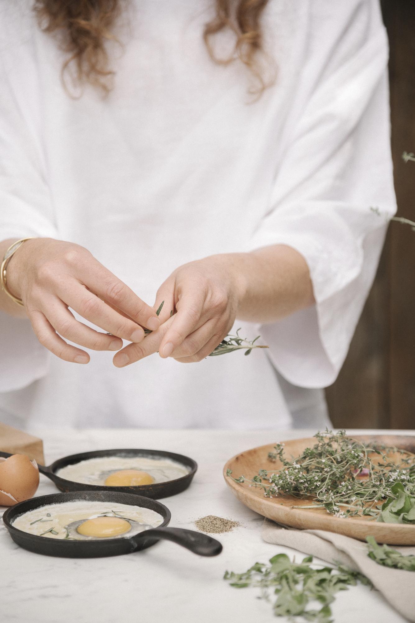 hands placing herbs on a plate in a studio kitchen